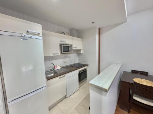 a white kitchen with a sink and a refrigerator at ApartHome Domocenter in Bormujos