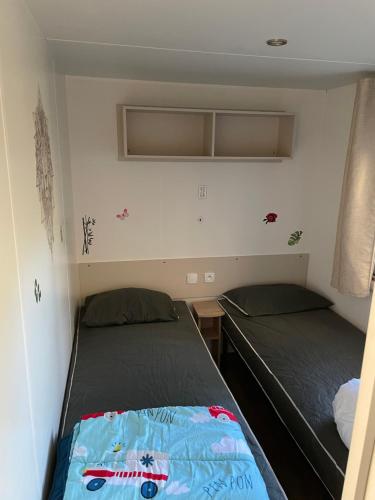- 2 lits dans une petite chambre avec 2 lits dans l'établissement Camping Siblu Bonne Anse Plage MH 6-8 personnes tout confort, aux Mathes