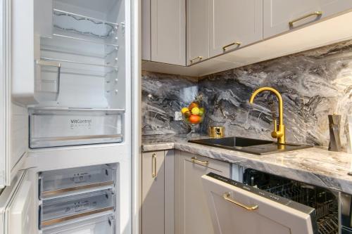 a kitchen with a sink and an open refrigerator at Hotel Mieszko in Gorzów Wielkopolski