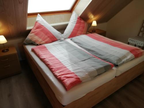 a bedroom with a bed with pillows and a window at Ferienwohnung Gartenblick mit Balkon in Maasholm