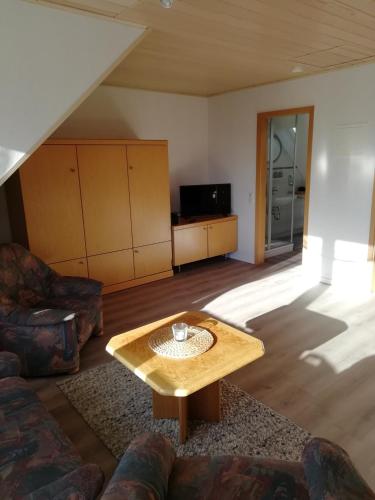 a living room with a table and a couch at Ferienwohnung Gartenblick mit Balkon in Maasholm