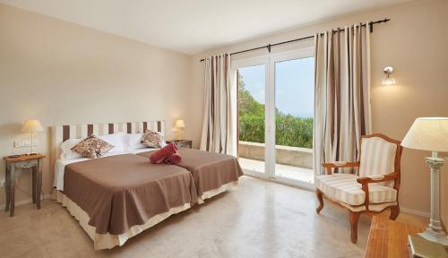 a bedroom with a bed and a large window at Can Pascalou in Canyamel