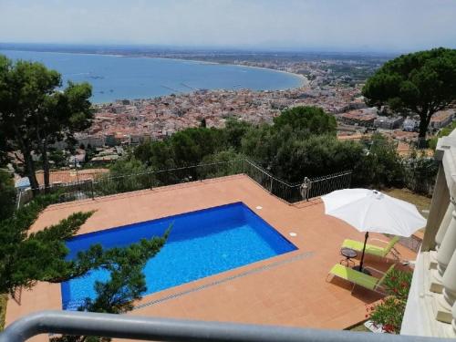 a swimming pool with an umbrella and a view at Casa Dorada in Roses