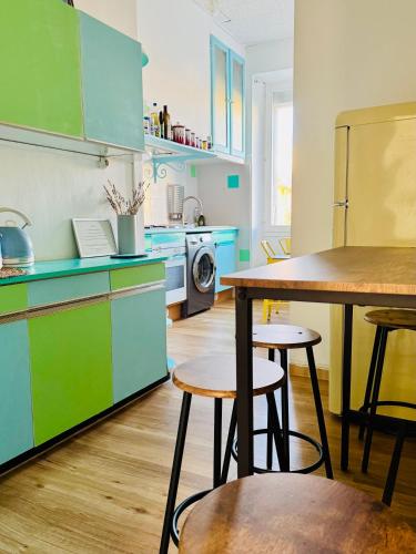 une cuisine avec des placards bleus et verts et une table dans l'établissement Authentique T3 calme entre mer et Calanques, à Marseille