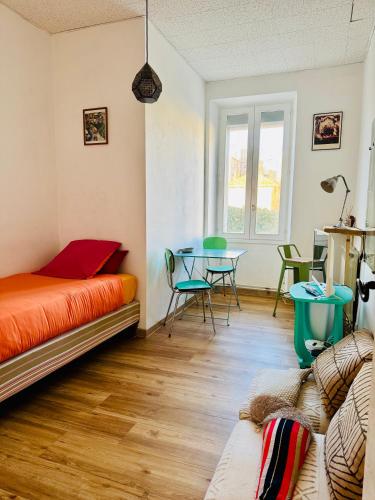 une chambre avec un lit, une table et des chaises dans l'établissement Authentique T3 calme entre mer et Calanques, à Marseille