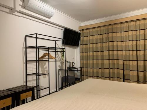 a bedroom with a bed and a desk and a window at Discovery Apartment Carnaxide in Carnaxide