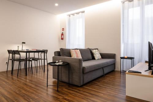 a living room with a couch and a table at Cozy Figueira Apartment in Figueira da Foz