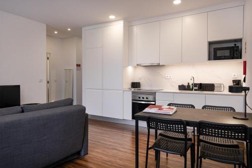 a kitchen and living room with a table and a couch at Cozy Figueira Apartment in Figueira da Foz