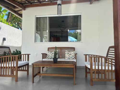 a patio with a table and chairs and a window at Vivendas Jauá in Camaçari