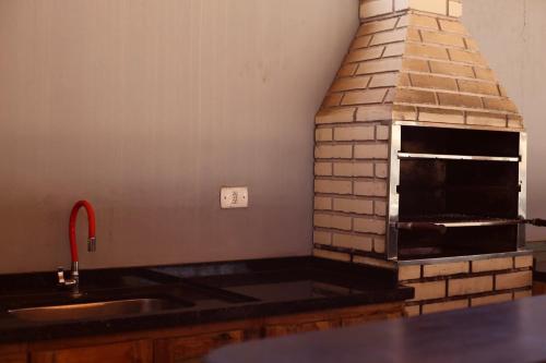 a kitchen with a brick oven and a sink at Meu Hotel Boituva in Boituva