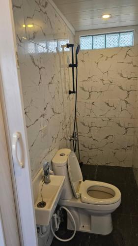 a bathroom with a white toilet and a sink at Lydias House samal kaputian in Kaputian