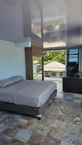 a bedroom with a bed and a large window at Lydias House samal kaputian in Kaputian