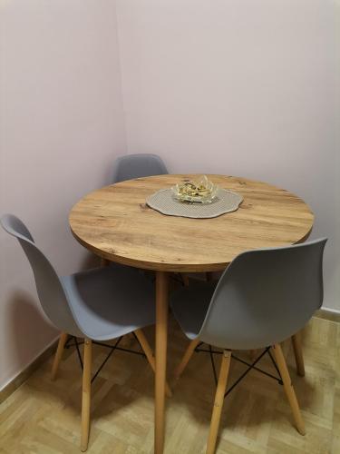 a wooden table with four chairs and a plate on it at Apartman petrov 1 in Pančevo