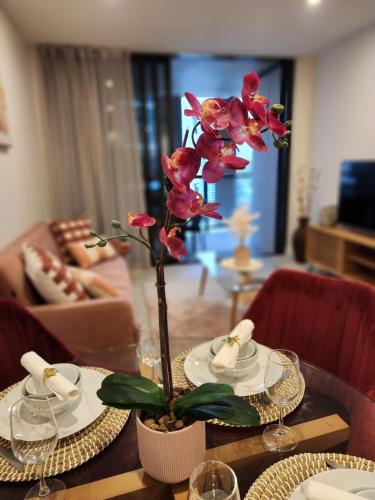 a table with a vase with a flower on it at Free Car Park, Infinity Pool, City View, Spa-Sauna in Brisbane