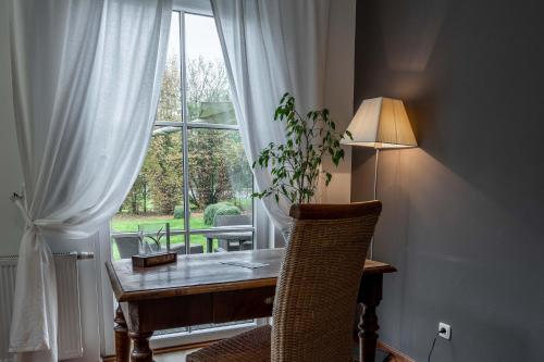 a desk with a lamp in front of a window at Apartments am Schloss Mühldorf in Feldkirchen an der Donau
