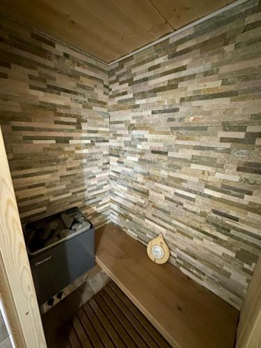 une petite pièce avec un mur de pierre avec une horloge dans l'établissement 4 Seasons for 8 persons with Sauna and Local Ski, à Isola
