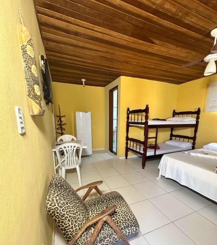 a room with a bedroom with a bed and a desk at Suites do Peró in Cabo Frio