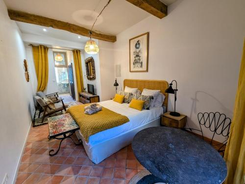une chambre avec un lit et une chaise dans une pièce dans l'établissement La Suite Lume - Clim et terrasse, à Arles