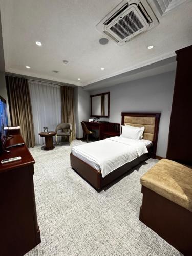 a hotel room with a bed and a desk at Mir Luxe Plaza in Tashkent