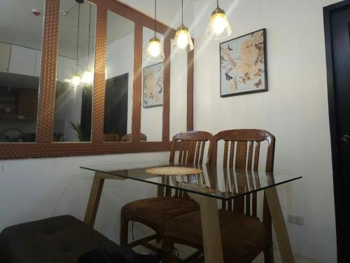 a dining room with a glass table and two chairs at V Cozy Haven in Baguio