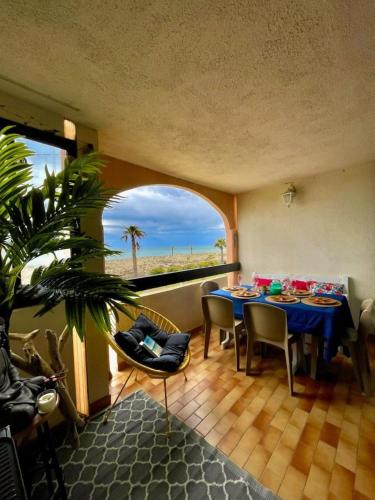 une salle à manger avec une table et une vue sur la plage dans l'établissement Beach apartment, au Barcarès