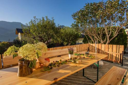 a wooden table with vegetables and flowers on a patio at Landhaus Seraphine - by myNests in Assachberg