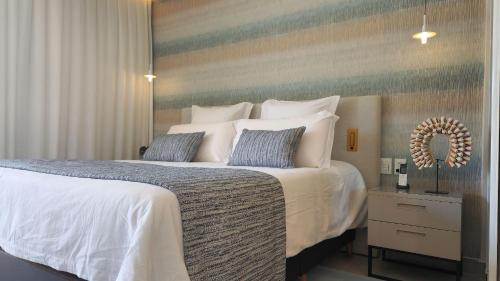 a bedroom with a large bed with white sheets and pillows at île de Pipa - Ma Plage Hotel in Pipa