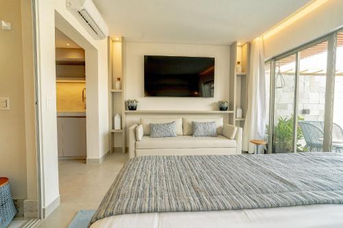 a bedroom with a white bed and a couch at île de Pipa - Ma Plage Hotel in Pipa