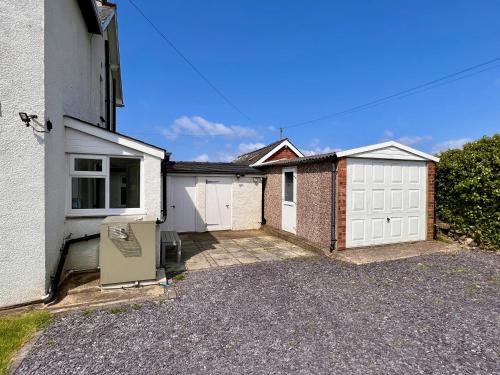 a house with a white garage and a driveway at Glynmor in Harlech