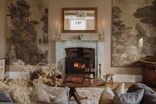 a living room with a fireplace and a table at Cartmel Old Grammar in Cartmel