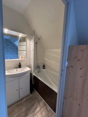 a bathroom with a sink and a bath tub at Hôtel Restaurant La Voile Bleue in Erdeven