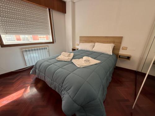 a bedroom with a bed with two towels on it at Torre 15 in A Coruña