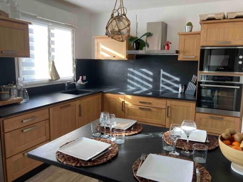 une cuisine avec une table avec des verres à vin dessus dans l'établissement Maison-Biscarrosse ville-6 pers-lac-océan, à Biscarrosse