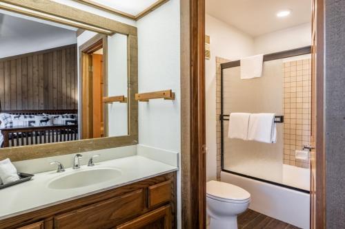 a bathroom with a sink and a toilet and a mirror at Mountainback 19 Loft Den in Mammoth Lakes