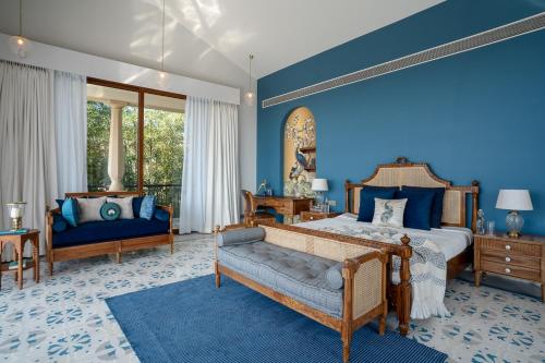 ChopdemにあるLohonoStays Sacri Borod Hill Villa 4の青い壁とベッドとソファのある寝室