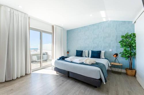 a bedroom with a large bed and a large window at Malpique heated pool & Jacuzzi Guest House in Albufeira