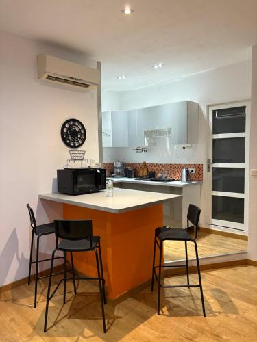 une cuisine avec un comptoir et deux tabourets dans l'établissement Le Léon Noel, à Cannes