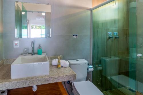 ein Badezimmer mit Toilette, Waschbecken und Dusche in der Unterkunft Residencial Falésias de Pitinga in Arraial d'Ajuda