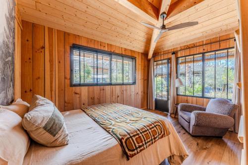 a bedroom with a bed and a ceiling fan and windows at VillaCanau in Lacanau
