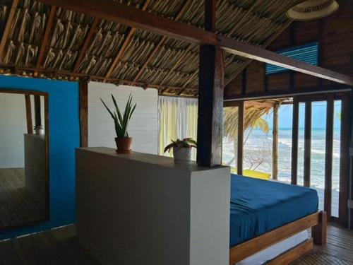 una camera con letto e vista sulla spiaggia di Entre Palmas Cabañas a Moñitos