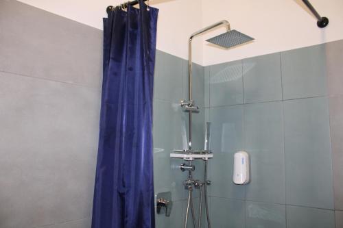 a shower with a blue shower curtain in a bathroom at Roma Scout Center in Rome