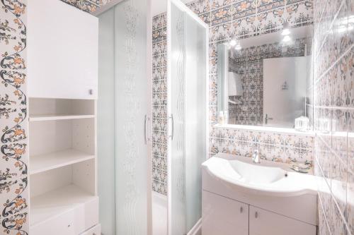 une salle de bain avec un lavabo et un miroir dans l'établissement Le Cap Normand - Vue mer, à Cabourg