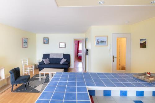 - un salon doté de carrelage bleu dans l'établissement Le Cap Normand - Vue mer, à Cabourg