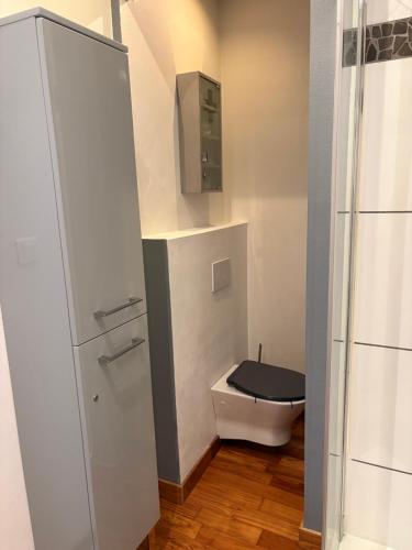 La salle de bains est pourvue de toilettes et d'un couvercle noir. dans l'établissement Le Léon Noel, à Cannes