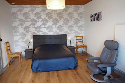 une chambre avec un lit et deux chaises dans l'établissement Maison des Carmes Plurien, à Plurien