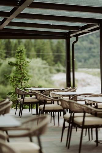 a group of chairs and tables on a deck at Valbona Resort & Spa in Valbonë