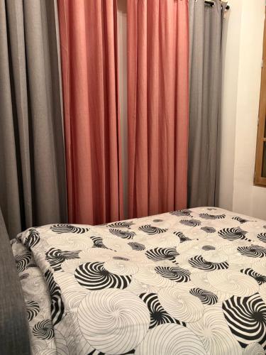 Ce lit se trouve dans un dortoir doté de rideaux rouges. dans l'établissement Le Léon Noel, à Cannes