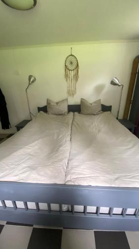 a bed in a room with two lights on the wall at Forest Seaside living in Vallda Kattegatt trail in Vallda