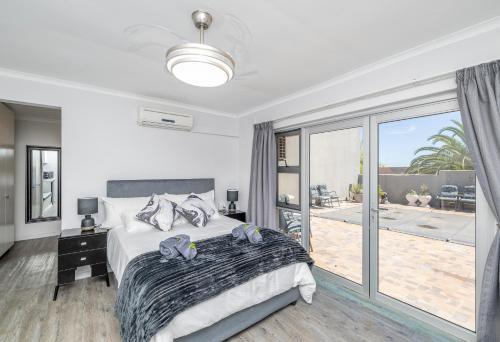 a white bedroom with a bed and a balcony at Infinite Studio str in Panorama