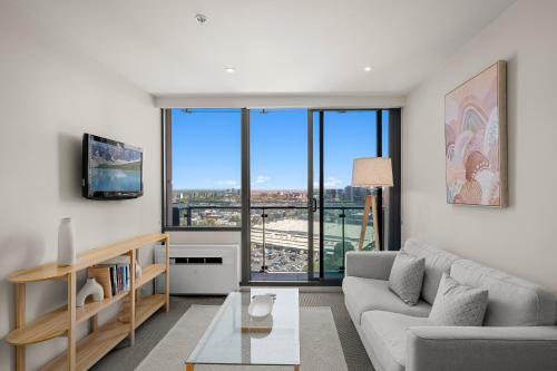 a living room with a couch and a table at City Stays - Plus in Melbourne